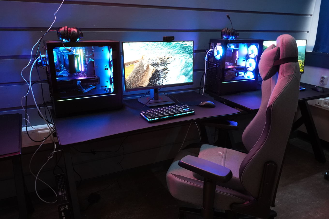 a person's foot on a desk with a computer and a keyboard